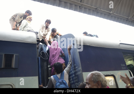 Uomo indiano tirando verso l'alto e la donna l'arrampicata sul tetto del treno vano carrello Jodhpur Rajasthan India Asia Foto Stock