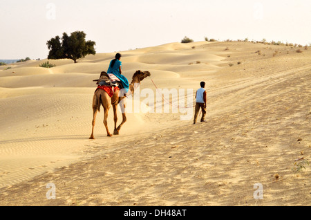 Donne equitazione a dorso di cammello nel deserto del Rajasthan India Asia Foto Stock