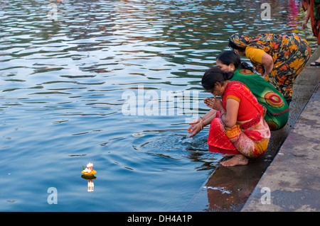 Donne pregando offrendo lampada diya al fiume Godavari Nasik Maharashtra India Asia NOMR Nove 2011 Foto Stock