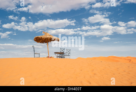 Ombrellone e sedie nel deserto Foto Stock