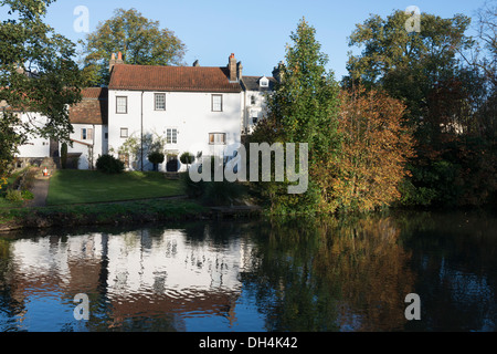 Una casa sulla riva del fiume lungo il fiume Cam in Cambridge Regno Unito riflessa nell'acqua su una soleggiata giornata autunnale Foto Stock