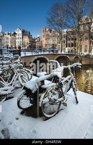 I Paesi Bassi, Amsterdam, Canal case nel canale chiamato Singel. Unesco - Sito Patrimonio dell'umanità. Le biciclette. Inverno, la neve Foto Stock