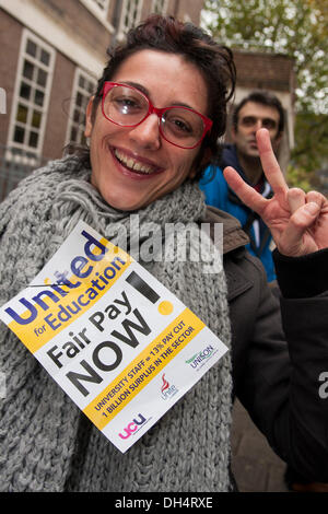 Londra, Regno Unito. Il 31 ottobre 2013. Un manifestante dà una 'V' segno come supporto agli studenti che colpisce l'insegnamento e il personale di supporto alla domanda più equa aumenti salariali e un salario di sussistenza per a bassa retribuzione dei lavoratori universitari. Credito: Paolo Davey/Alamy Live News Foto Stock