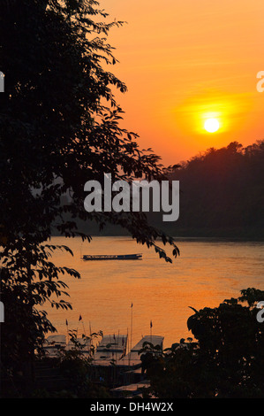 Vista verticale attraverso il fiume Mekong al tramonto con una barca a vela attraverso. Foto Stock