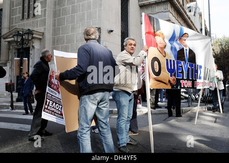 Salonicco, Grecia. Il 31 ottobre 2013. Piccoli obbligazionisti tenere un banner con la foto della Grecia del Primo Ministro Antonis SAMARAS, centro, Germania il Cancelliere Angela Merkel, a sinistra e a destra il vice primo ministro Evangelos Venizelos. Il banner si legge "il bugiardo e il ladro". Obbligazionisti protesta al di fuori della Banca di Grecia. In occasione della Giornata mondiale del risparmio di circa 50 piccoli obbligazionisti che hanno subito gravi perdite durante la Grecia del massiccio del debito pubblico writeoff lo scorso anno, affermano di essere stati ingannati dal governo e chiedono il risarcimento. Credito: Konstantinos Tsakalidis/Alamy Live News Foto Stock