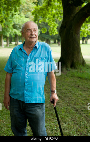 Uomo anziano con un bastone da passeggio in un parco Foto Stock