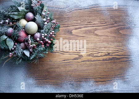 Decorazione di natale con abeti e baubles su sfondo di legno. Foto Stock