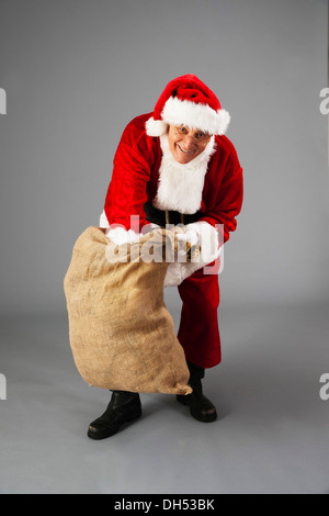 Santa rummages in un sacchetto Foto Stock