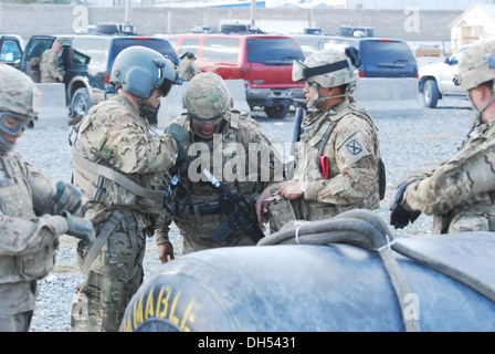 Sgt. Daniel Glenn, un CH-47 elicottero Chinook tecnico di volo dal Texas Guardia nazionale, di servire sotto il decimo di combattimento Brigata Aerea, discute sling strategia di carico con seconda Lt. Huggins Tireese dalla e società, 3° Battaglione (supporto generale), decimo C Foto Stock