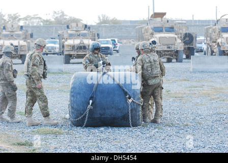 Sgt. Daniel Glenn, un CH-47 elicottero Chinook tecnico di volo dal Texas Guardia nazionale, di servire sotto il decimo di combattimento Brigata Aerea, discute sling strategia di carico con i membri della società E, 3° Battaglione (supporto generale), decimo cabina, prima di imbracatura Foto Stock