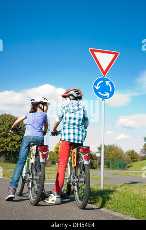 Bambini su biciclette a un semaforo con un corso di sensibilizzazione Foto Stock