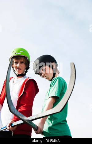 Due fantastici ragazzi giocare hockey a rullo con bastoni da hockey Foto Stock