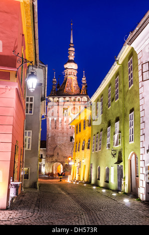 Via medievale in Sighisoara con torre dell'Orologio costruita per proteggere la porta principale della città sassone, punto di riferimento della Transilvania in Romania Foto Stock