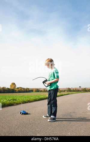 Ragazzo giocando con la sua radio-controllato auto modello Foto Stock