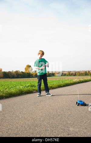 Ragazzo giocando con la sua radio-controllato auto modello Foto Stock