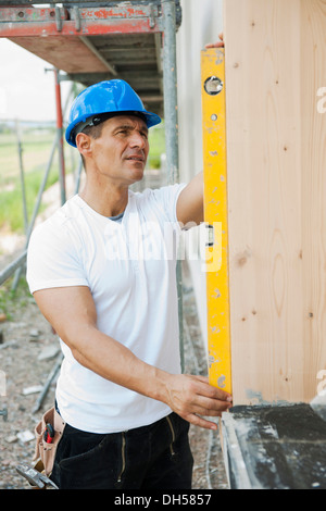 Costruzione manager controlla la finestra Installazione con un livello di spirito, Mannheim, Baden-Württemberg, Germania Foto Stock