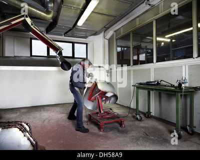 La macinazione del lavoratore un parafango in un workshop, Kundl, Distretto di Kufstein, Nord Tirolo Tirolo, Austria Foto Stock