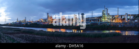 Le luci della sera dalla Ineos Chlor prodotto chimico industriale opere sul fiume Mersey estuario a Runcorn Cheshire Regno Unito Foto Stock