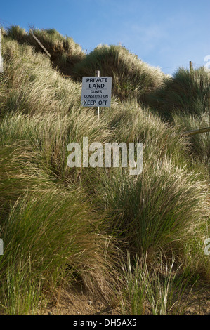 Spiaggia di dune di sabbia di erba a Mawgan Porth Beach in Cornovaglia con un terreno privato segno, dicendo tenere spento Foto Stock