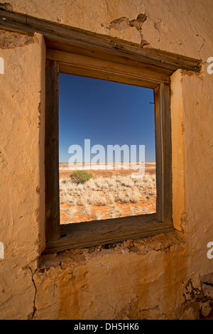 Vista del paesaggio dell'entroterra di vaste pianure aride e cielo attraverso la finestra di edificio rovinato a Edwards Creek sul Oodnadatta Track Sud Australia Foto Stock