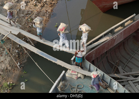 I vettori lo scarico di una nave con sacchi di cemento, Fiume Turag, Gabtoli, Dhaka, Bangladesh, Asia del Sud, Asia Foto Stock