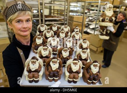 Hornow, Germania. 30 ott 2013. Dipendente Simone Bubner dal pasticcere Felicitas GmbH rimuove i bit del cioccolato da un cioccolato schiaccianoci in Hornow, Germania, 30 ottobre 2013. La produzione per il Natale ha già iniziato nell'impresa familiare. Solo il puro burro di cacao viene utilizzato per rendere le figure fatte a mano. Circa 300 chili di cioccolato è un processo lì ogni giorno. Foto: Patrick Pleul/dpa/Alamy Live News Foto Stock