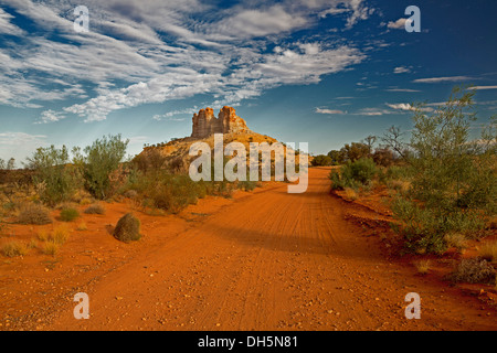 Outback paesaggio con rossa lunga strada che attraversa le pianure di Castle Rock, unica caratteristica geologica nel Territorio del Nord Australia Foto Stock