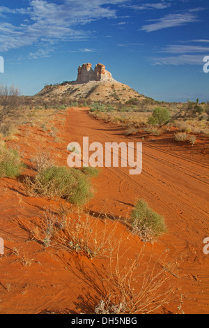 Outback paesaggio con rossa lunga strada che attraversa le pianure di Castle Rock, unica caratteristica geologica nel Territorio del Nord Australia Foto Stock