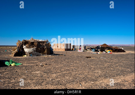 Tenda nomade e abitazioni di una famiglia di nomadi su un altopiano deserto pietroso, hamada, Erg Chebbi, sud del Marocco, Marocco, Africa Foto Stock