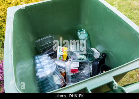 Green wheely cassone pieno di contenitori di plastica alimentare per il riciclaggio raccolta, REGNO UNITO Foto Stock