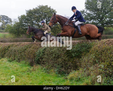 Queniborough, Leicestershire, Regno Unito. 1 novembre 2103. Come Madre e come figlia. Harriet Gibson e sua madre Zoe affrontare un enorme hedge durante il Quorn Hunt soddisfare il primo di Novembre, il tradizionale inizio della caccia alla volpe stagione. Credito: Nico Morgan/Alamy Live News Foto Stock