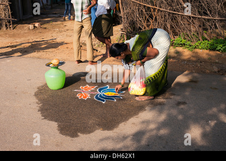 Donna indiana facendo una Lotus Rangoli di onorare la Sri Sathya Sai Baba outreach mobile servizio ospedaliero presso un villaggio indiano. Andhra Pradesh, India Foto Stock