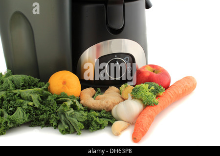 Spremiagrumi circondato da sani verdure come le carote e lo zenzero e kale, pronto a fare succo Foto Stock