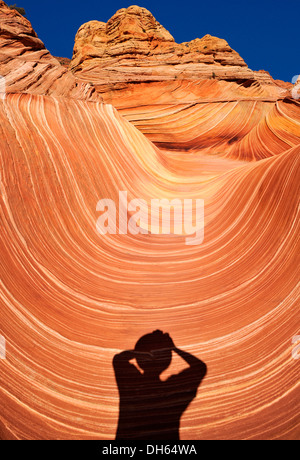 Ombra di un fotografo presso "l'Onda' ondata di bande Navajo erose rocce di arenaria con bande Liesegang, Coyote Buttes North, Foto Stock