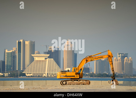 Boom edilizio a Doha, escavatore Hyundai di fronte lo skyline, Hotel Doha Sheraton Four Seasons Hotel Foto Stock