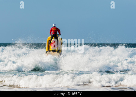 Un bagnino RNLI su un jetski pattugliamento a Fistral Beach. Foto Stock