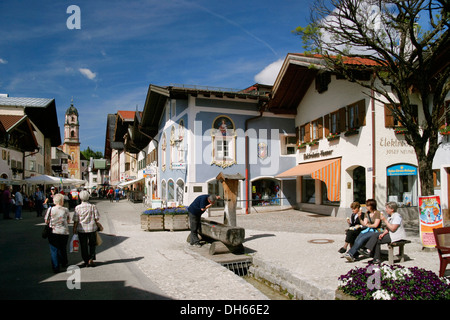 La zona pedonale a Mittenwald con la chiesa parrocchiale di San Pietro e Paolo, Werdenfelser Land regione, Alta Baviera, Baviera Foto Stock