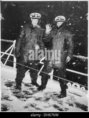 Due ufficiali della Guardia Costiera degli Stati Uniti sono visti sopportare dure condizioni invernali a bordo di un cutter mentre erano in pattuglia nel Nord Atlantico. La taglierina svolge un ruolo fondamentale nella sicurezza marittima e nella sicurezza nella regione in caso di condizioni meteorologiche avverse. Foto Stock