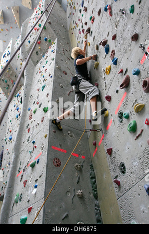 Climber di piombo-clipping in oltre la linea di sicurezza in Kletterzentrum Amburgo centro di arrampicata, Amburgo Foto Stock