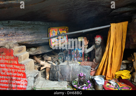 Sadhu vive in una grotta vicino al villaggio di Mana, India Foto Stock