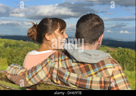 Una giovane coppia seduta su una panchina, hegaublick, BADEN-WUERTTEMBERG, publicground Foto Stock