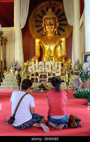 Matura in ginocchio davanti alla statua del Buddha, Chiang Mai, Thailandia, Asia Foto Stock