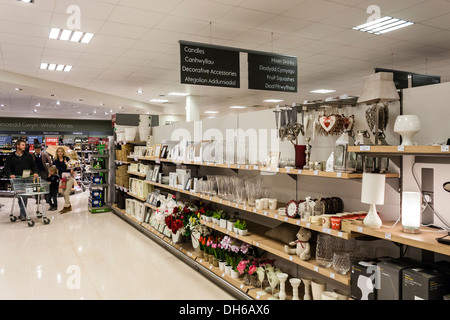 Famiglia giovane navigare home prodotti nella sezione di corridoi di un supermarket Waitrose in Galles con segni in gallese e inglese. Foto Stock