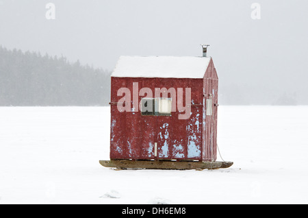 Un ghiaccio rosso-rifugio di pesca in una tempesta di neve sul Lago Eagle, Parco Nazionale di Acadia, Maine. Foto Stock