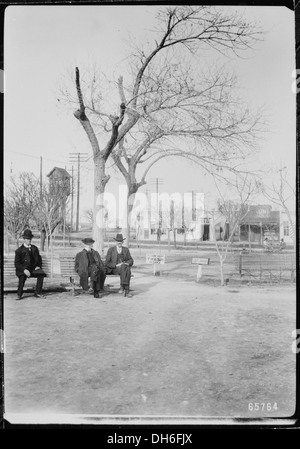 Tre uomini siedono su una panchina del parco a San Jacinto Plaza, El Paso, Texas, nel 1906, passando casualmente del tempo nello spazio pubblico storico. Foto Stock