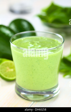 Rinfrescante sano frullato verde fatta di freschi di avocado, spinaci, lime e yogurt in un vetro su legno luminoso Foto Stock