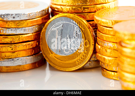 Pila di cioccolato Euro denaro in primo piano su sfondo bianco Foto Stock