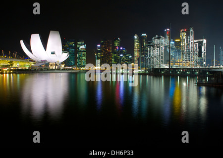 Singapore Art Museo della Scienza illuminata, Marina Bay e il quartiere degli affari di notte. Foto Stock