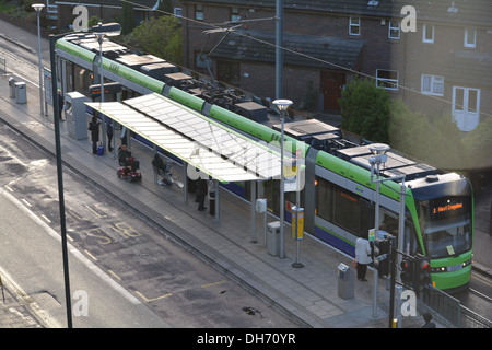 Il Tram che viaggiano attraverso Croydon, avvicinandosi alla fermata del tram. Foto Stock