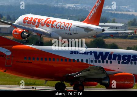 L'atterraggio dell'aereo easyJet e lo smartwings dell'aereo in attesa del decollo dall'aeroporto di Praga Foto Stock